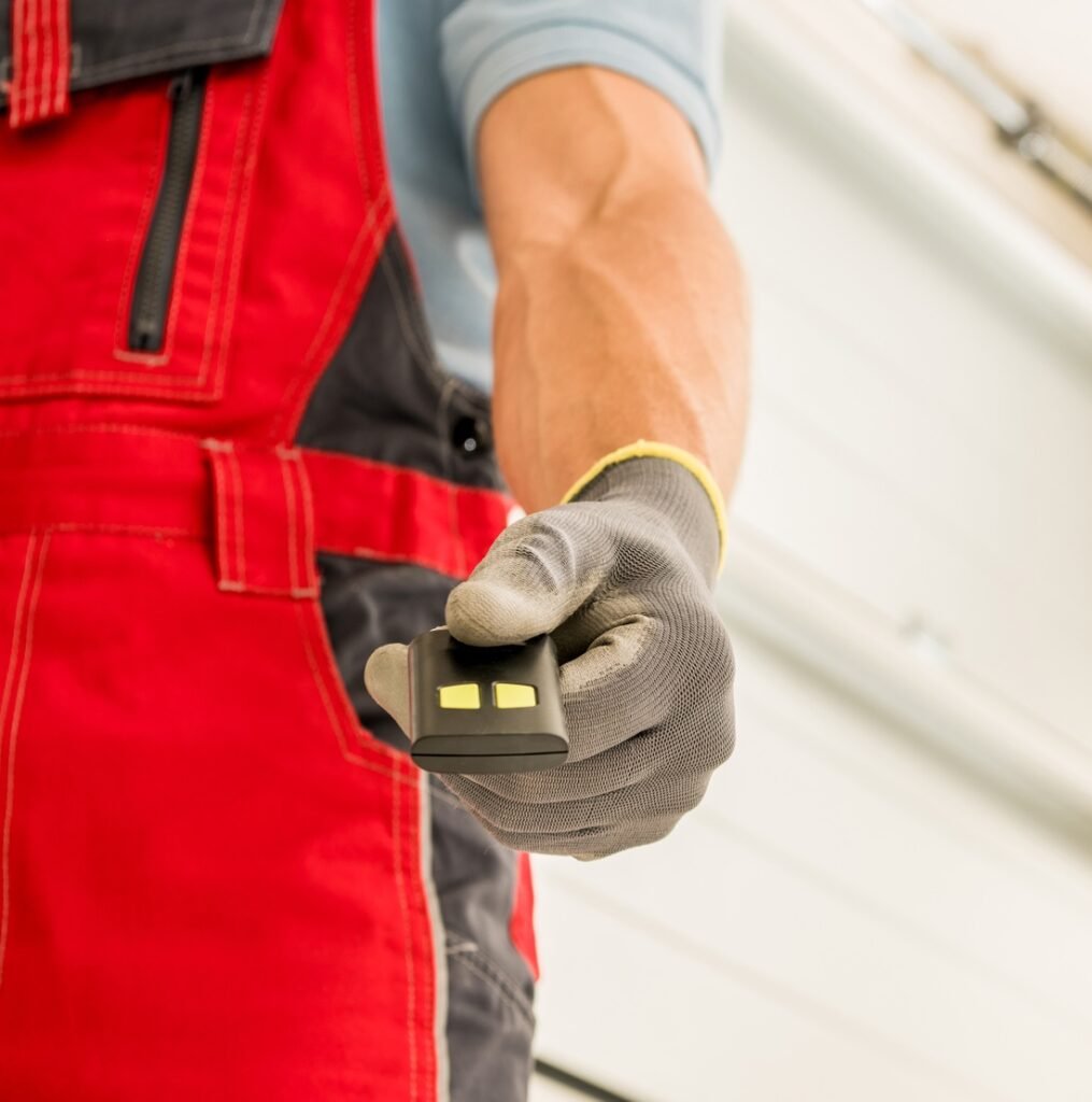 Garage Doors Installer Finishing His Work and Deliver Door Remote Controller
